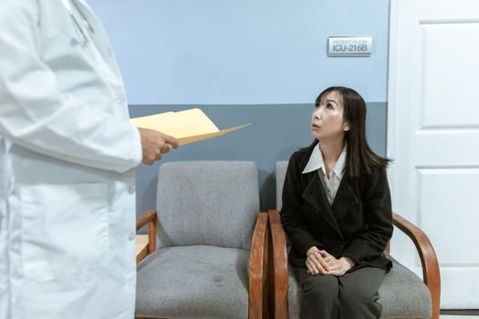 couple sitting together looking worried at clinic waiting room