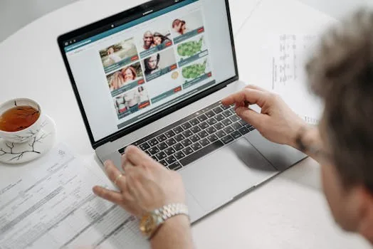 person using macbook laptop coffee shop checking screen