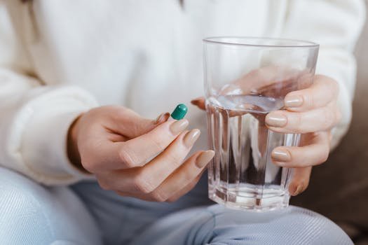 woman drinking water with supplement capsule morning routine