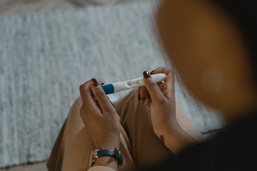 woman holding positive pregnancy test emotional moment