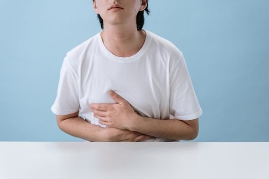 woman holding stomach nausea discomfort digestive pain