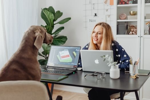 woman satisfied looking at creative design on laptop screen home office