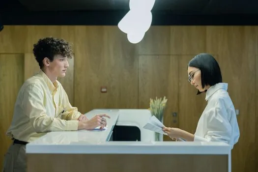 Korean driver reading mobile ID QR instructions at a driving test center reception desk, realistic public office scene, warm editorial lighting