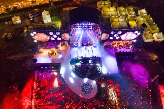 Korean outdoor music festival audience watching a bright wet stage from far distance, no explicit pose, evening lights