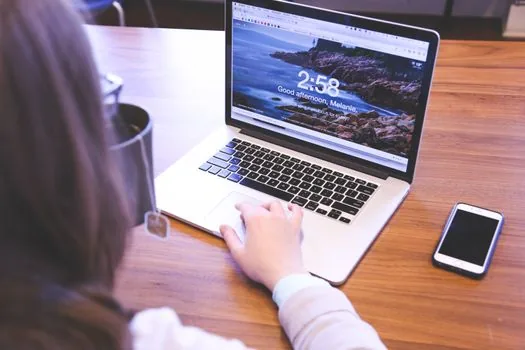 Korean user checking Google account recovery options on smartphone and laptop, realistic desk