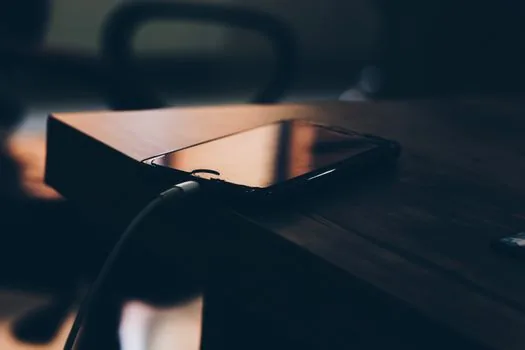 old smartphone and new smartphone on a table with chat backup checklist and charging cable, realistic Korean digital life photo | 새 휴대폰으로 카카오톡 대화를 옮기기 전 확인할 준비물