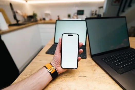 person checking smartphone map history backup status beside old phone and new phone on table, realistic privacy settings scene, no readable text
