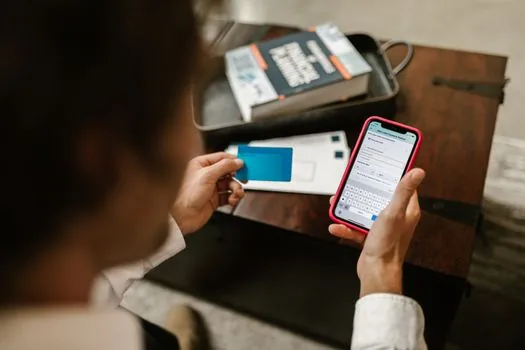 person comparing old phone and new phone with security code recovery checklist on table, realistic account security scene, no readable text