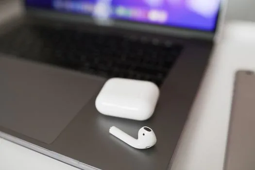 close-up of Windows sound settings with blurred Bluetooth earbuds output and volume slider, wireless earbuds case on desk, realistic editorial photography, no readable personal data | 블루투스 이어폰 소리 출력과 볼륨을 점검하는 장면