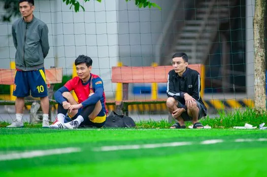football tactical board showing Group A standings magnets for Vietnam Singapore Indonesia Cambodia Timor Leste, coach hand pointing at semifinal route, sports newsroom lighting, no readable tiny text | 조별 순위와 4강 진출 경우의 수를 전술판으로 확인하는 장면