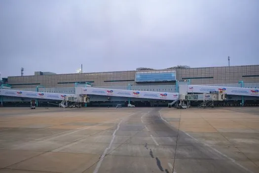 Incheon airport departure gate with passengers waiting near boarding screen, airline crew coordinating boarding, realistic Korean travel news photo