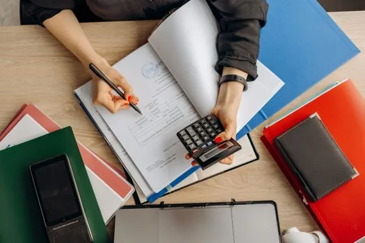 Korean citizen reviewing dormant deposit claim application on official finance website with identity card and deposit amount note, practical bright desk