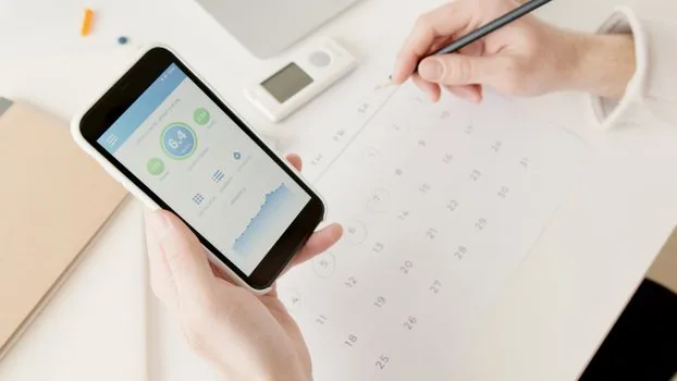 Korean hand comparing card statement monthly fee and refund calendar on smartphone, clean kitchen table, practical subscription management photo | 월회비 결제와 환불 처리 기간을 확인하는 장면