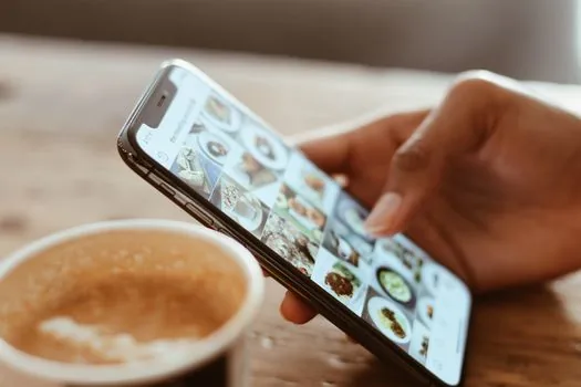 Korean smartphone showing cloud photo backup settings beside gallery thumbnails and data usage notification, realistic bright home desk | 네이버 MYBOX 자동 올리기 설정을 확인하는 장면