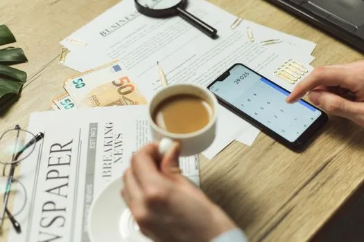Korean user organizing account security checklist with backup codes, recovery email and new phone on wooden desk, realistic bright editorial photo