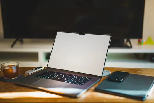 laptop showing telecom refund lookup form with identity verification phone beside it