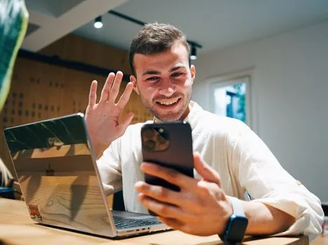 person comparing video recommendation feed settings on phone and laptop, calm realistic home desk, no logos enlarged, no readable personal data | 추천 영상이 달라지지 않을 때 계정과 기록 설정을 나눠 보는 장면