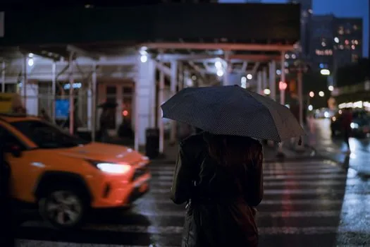 Person reviewing taxi ride details on phone with lost umbrella and expense receipt checklist, realistic city office entrance | 분실물 문의와 회사 제출용 택시 이용기록을 따로 정리하는 장면