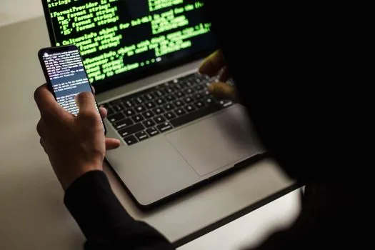 smartphone showing Telegram service message notification beside laptop login code input page, realistic close up, soft indoor light