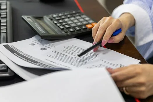 Korean adult reviewing national health insurance refund notice, hospital receipts and phone authentication screen at home desk, no readable personal data | 국민건강보험공단 안내문과 병원비 영수증을 함께 확인하는 장면