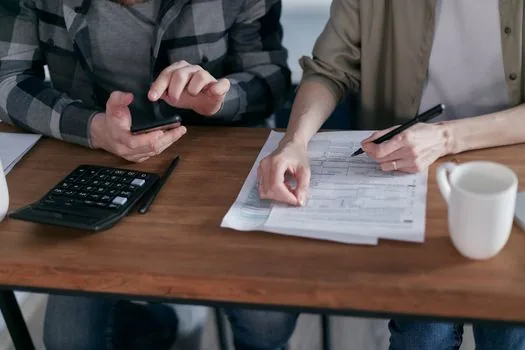 Korean apartment subscription documents with calculator and payment schedule on desk