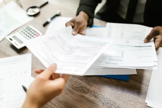 Korean citizen sorting local tax certificate, payment confirmation and loan documents on clean desk, realistic civic service photo