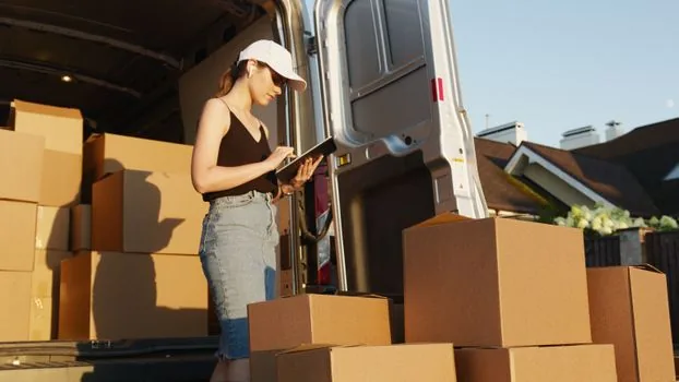 Korean government website address change and lease report checklist on laptop, moving boxes and lease documents nearby, realistic administrative photo