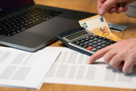 Korean national pension service consultation desk with pension booklet, calculator and application papers, realistic public office editorial photo