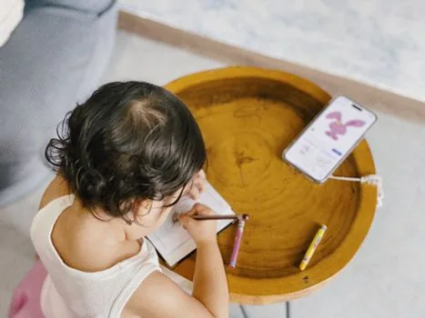 Korean parent checking child vaccination date and health booklet on dining table with smartphone calendar, bright realistic guide photo | 어린이 독감 예방접종 대상과 접종 횟수를 가족이 확인하는 장면