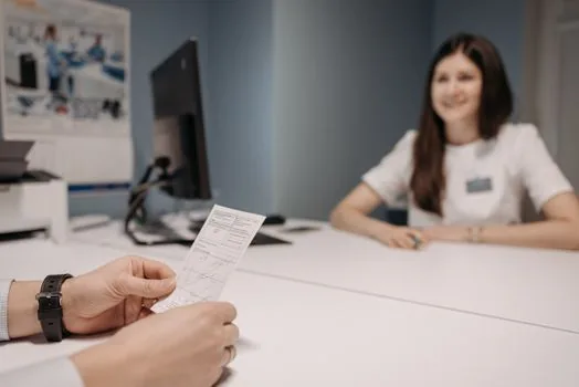 Korean patient talking with doctor about medical certificate for sick leave benefit, clinic consultation room, realistic editorial photography, no text