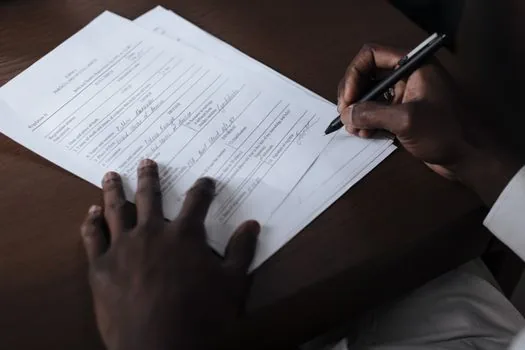 Korean tenant scanning a signed housing lease contract with laptop and apartment keys on desk, realistic daylight administrative paperwork photo