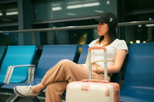 Korean traveler checking express bus mobile ticket cancellation screen at terminal waiting area | 모바일 예매 취소 전에 출발시각과 예매처를 확인하는 장면