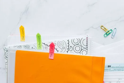 Korean worker organizing sick leave papers and return-to-work documents at home table, realistic editorial photography, no text