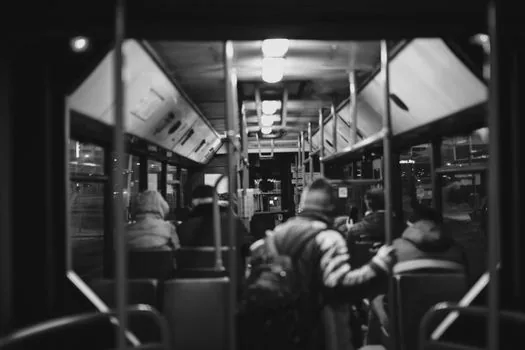 overheated Korean city village bus interior during summer commute, passengers holding hand fans and water bottles, realistic editorial photography, no readable text