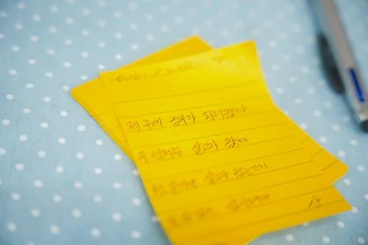 close-up of Korean lost item report checklist with wallet phone bag details, no readable text | 분실물 신고에 적을 물품 특징을 정리하는 장면