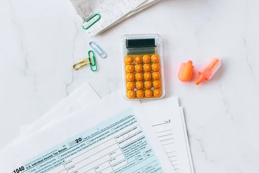 close view of senior living contract, deposit refund clause highlighted, calculator, pen and family checklist on wooden table