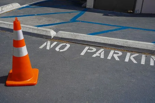close-up of orange traffic cone inside an urban tunnel lane with blurred approaching headlights, realistic safety warning composition
