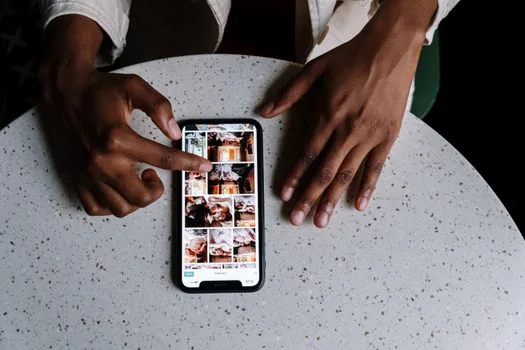 iPhone user turning on Maximize Compatibility while older laptop searches Wi-Fi nearby, realistic travel desk photo | 오래된 기기를 붙이기 위해 호환성 최대화를 확인하는 장면