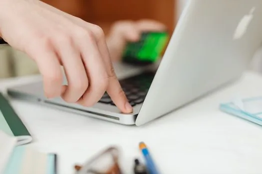 Korean buyer checking 25 percent mobile plan discount eligibility on laptop with used phone and SIM card nearby, clean realistic desk | 선택약정 할인 대상 단말기 조회를 확인하는 장면