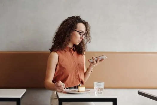 Korean person checking IMEI number in smartphone settings beside SIM tray pin and used phone receipt, realistic bright cafe table, no readable personal data | 중고폰 설정 화면에서 IMEI 번호를 확인하는 장면