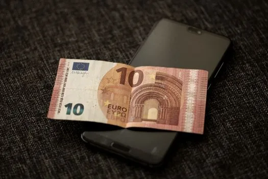 Korean phone bill with highlighted mobile payment charge, smartphone carrier app payment history, realistic desk photo