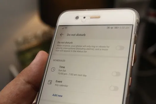 Korean smartphone showing notification app choices beside handwritten checklist for government alerts, realistic bright desk, no logos or readable private data