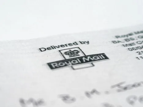 Korean user checking official road-name address lookup and postal code on laptop beside delivery parcel, realistic bright editorial photo, no private data | 공식 영문주소와 우편번호를 조회하는 장면