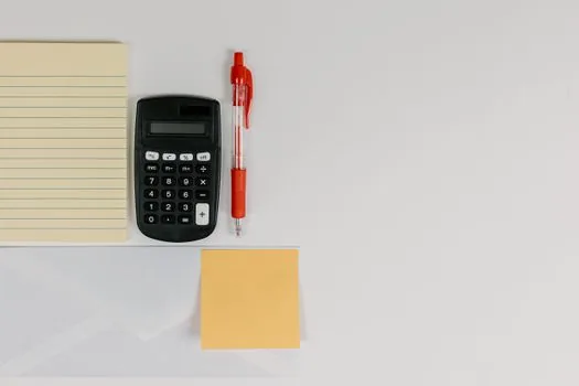 person filtering Gmail attachments by file size on laptop with calculator and sticky notes, realistic editorial photo, no readable text