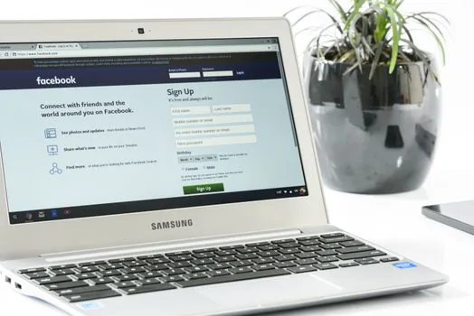 public computer desk with Telegram Desktop login screen and user entering one-time code on smartphone, realistic clean workspace