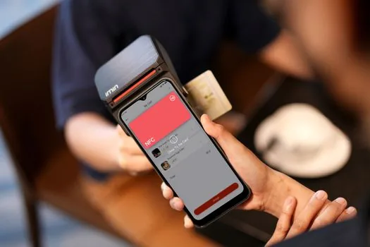 smartphone NFC tap near a physical driver license on a clean counter with soft daylight, realistic public service guide photo