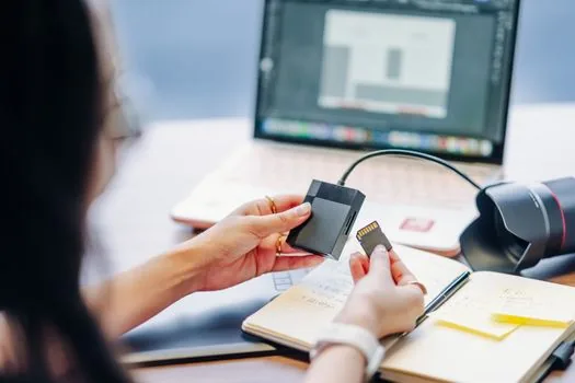smartphone showing Gmail storage warning beside laptop with Drive storage bar and family photo thumbnails, realistic Korean desk scene, no readable text