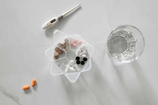Korean adult checking holiday pharmacy search results on smartphone before leaving home, medicine box and note on table, realistic editorial photo | 출발 전 약국 운영 여부와 전화번호를 확인하는 장면