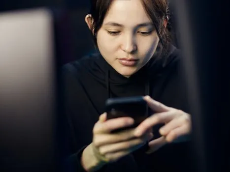 Korean adult reviewing privacy consent checklist on smartphone before government notification signup, soft daylight, realistic editorial photography, no readable text