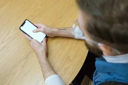 Korean blood donation center reception with donor checking reservation time on smartphone and ID card, bright realistic photo | 헌혈의집 방문 전 예약시간과 신분증을 확인하는 장면